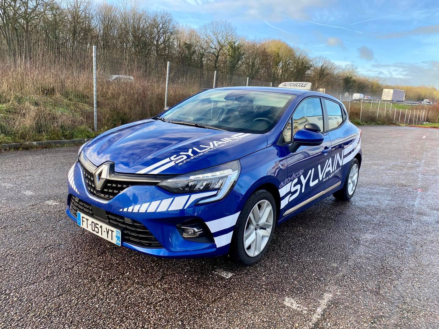 Pose de signalétique adhésive sur véhicule clio à l'auto-école Sylvain à Nancy 54